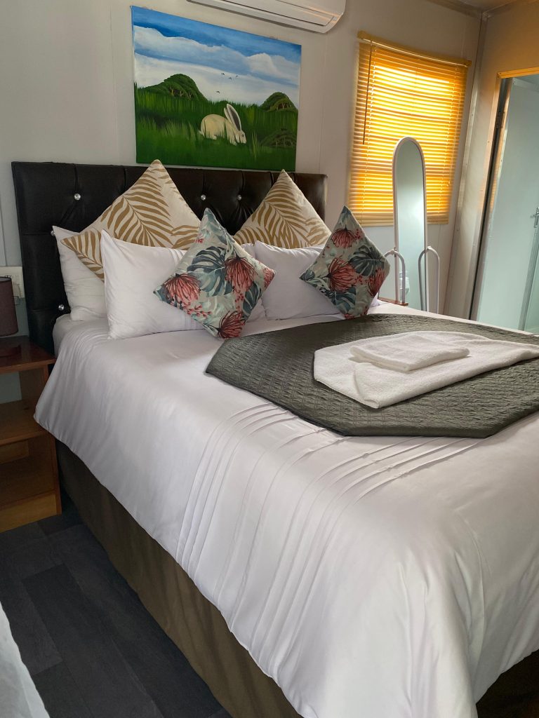 Queen Room at Mkhuze Inn with modern decor and comfortable bedding.